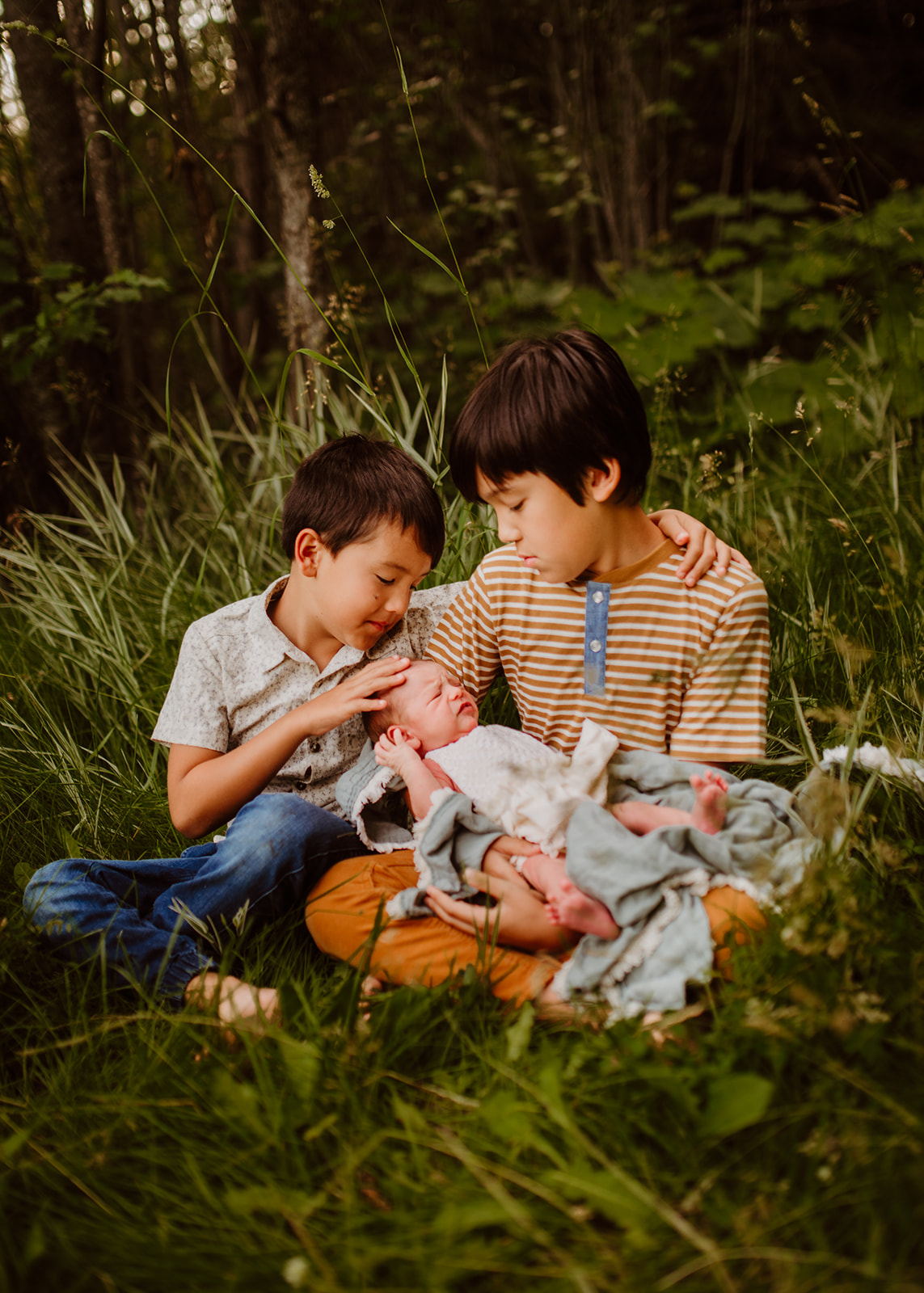 siblings holding new baby