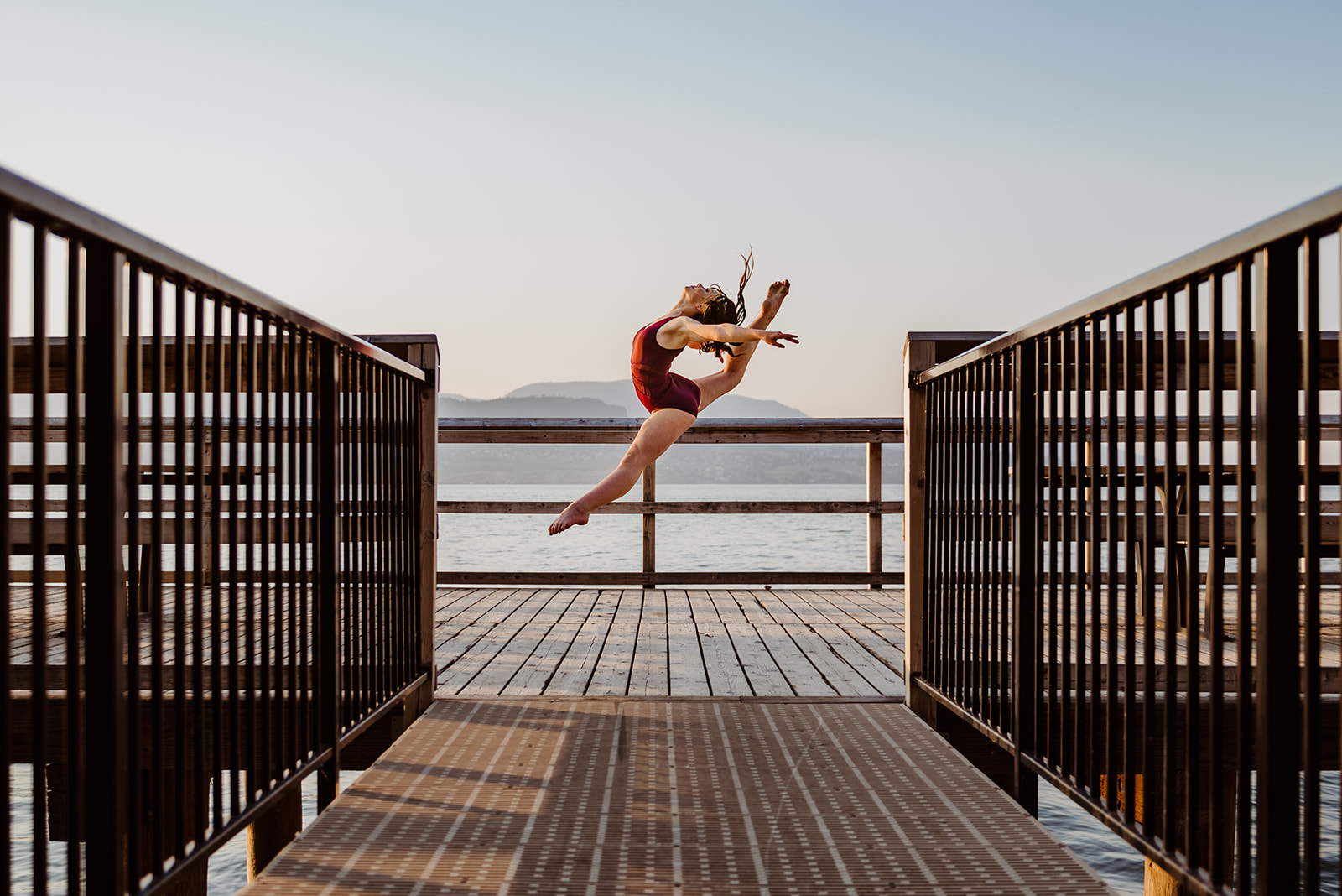 Okanagan Dance Photography 1 dancer in mid leap on Okanagan lake dock - dance and rhythmic gymnastic photos