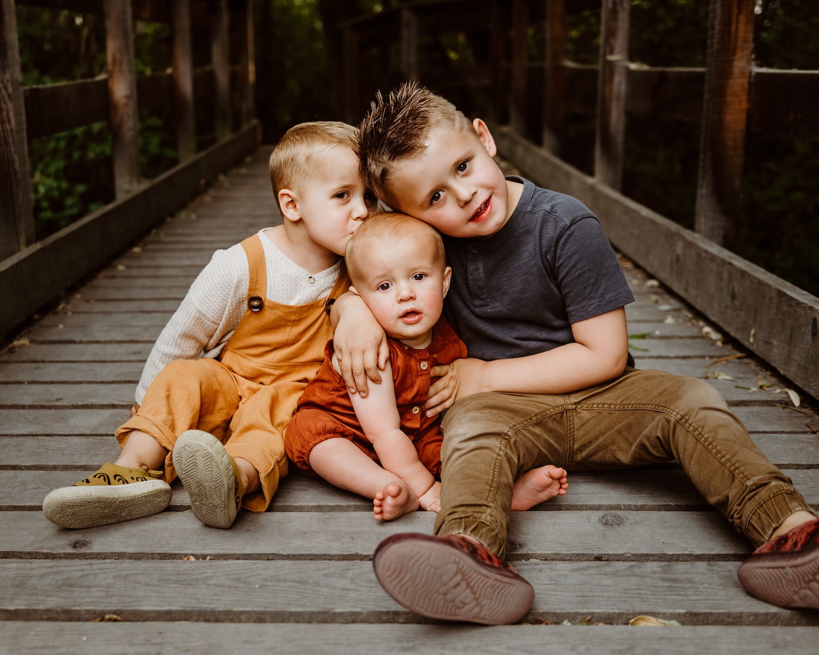 three little boys on a wooden bridge - sibling photoshoot