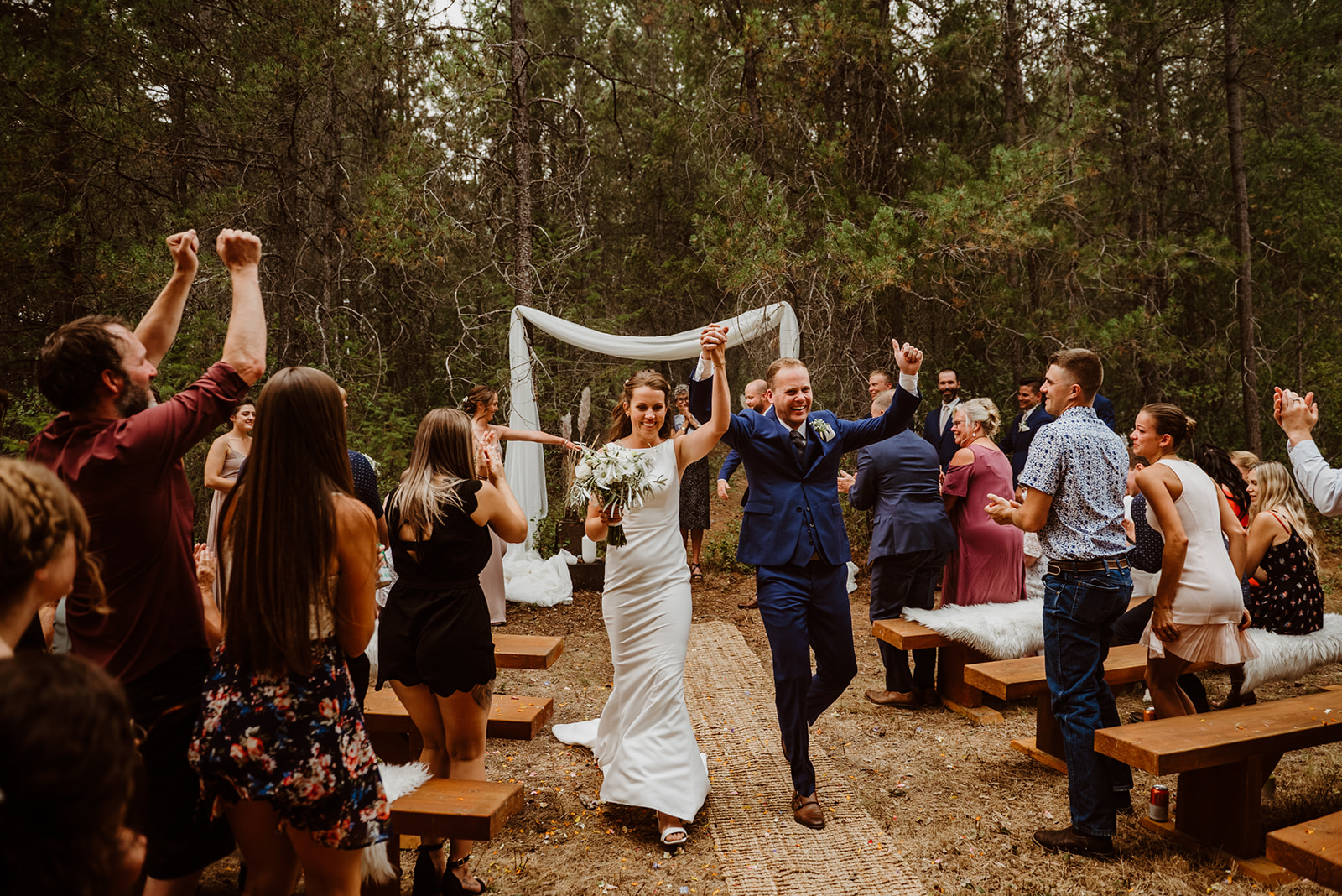 woods wedding couple walking back down the aisle after getting married outdoors in the rain